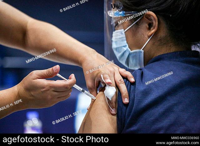 A health worker receives a dose of vaccine from China's Sinovac during a vaccination drive in San Juan City, Metro Manila, Philippines