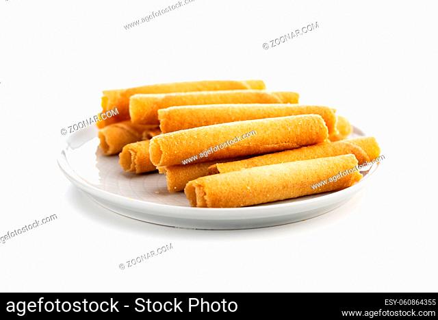 Sweet waffle tubes rolls on plate isolated on a white background
