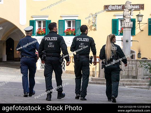 20 October 2020, Bavaria, Berchtesgaden: Policemen walk through the pedestrian zone of the city centre. From 14.00 hrs the exit restrictions in the...