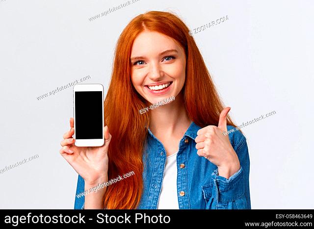 Close-up portrait satisfied good-looking redhead female using application, recommend download it, advertising photo app, online store
