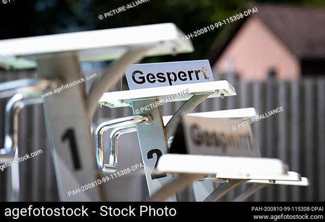 10 August 2020, North Rhine-Westphalia, Borgholzhausen: ""Closed"" can be read on a sign which is placed on the starting block in a closed outdoor swimming pool