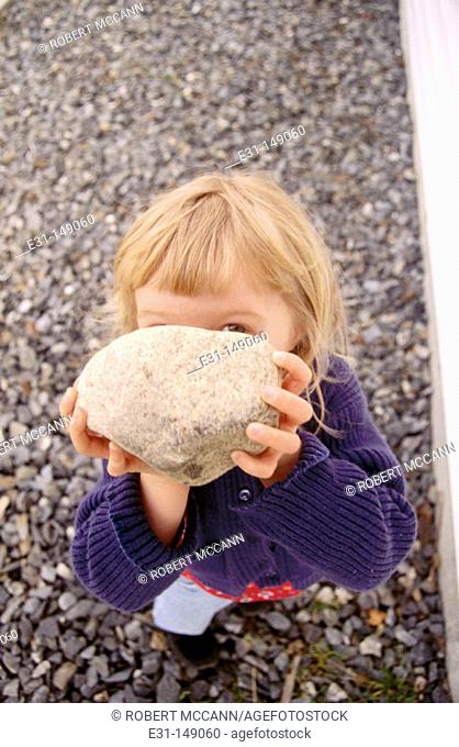 Young girl holding a rock
