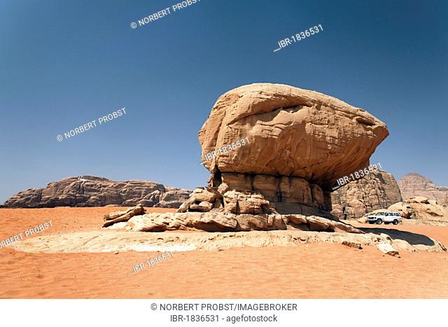 Off-road vehicle beside a mushroom-shaped rock formation, red sand, desert, plains, Wadi Rum, Hashemite Kingdom of Jordan, Middle East, Asia