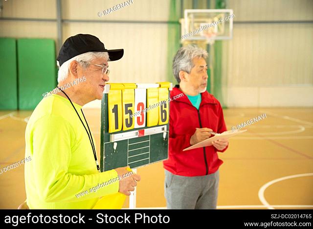 Senior man standing by score board
