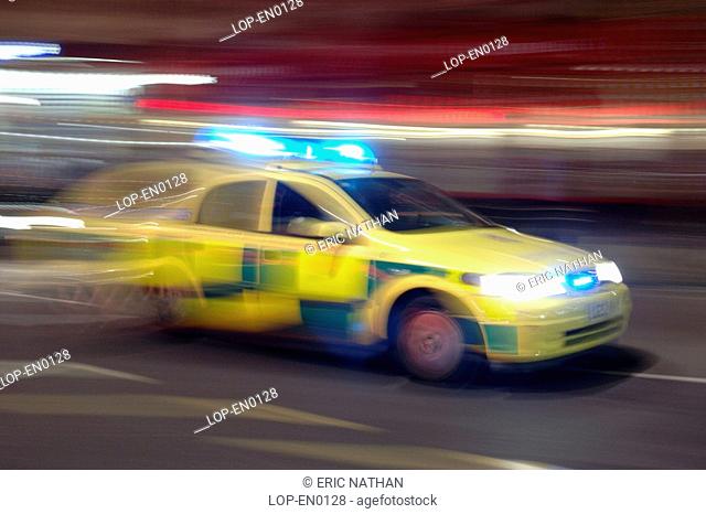 England, London, London, A police car speeding thorugh a London street at night. Over the past year the Metropolitan Police Service dealt with almost 110k cases...