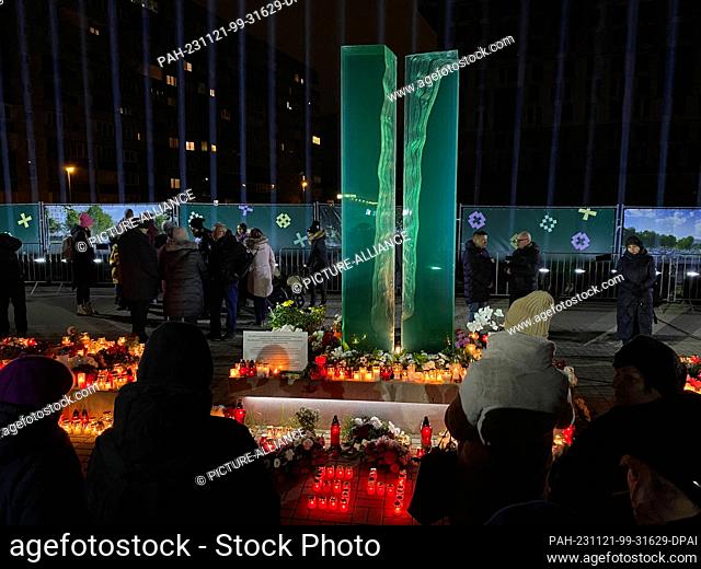 21 November 2023, Latvia, Riga: People stand at the memorial for the victims of the Riga collapse tragedy. Ten years after the collapse of a supermarket roof in...