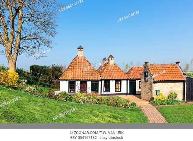 Tradtional Dutch countryside houses with garden near dike for protection to the sea