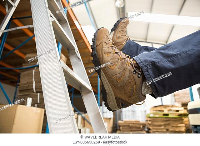 Worker falling off ladder in warehouse