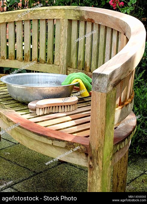 clean garden furniture after winter; soda (baking soda), brush and bowl