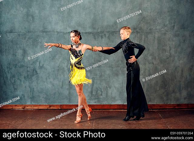 Ballroom dance samba. Young couple in yellow and black costumes dancing