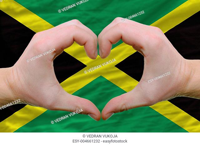 Heart and love gesture showed by hands over flag of jamaica back