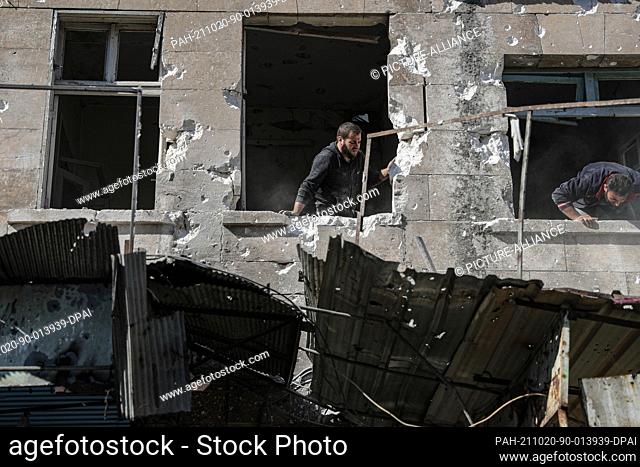20 October 2021, Syria, Ariha: Syrian men inspect a damaged house after it was targeted by a missile shelling in Ariha, allegedly carried out by Syrian...