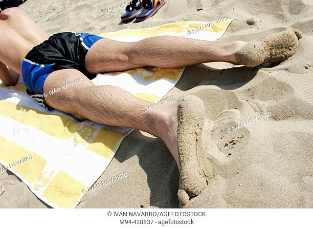 Person lying face down on the beach