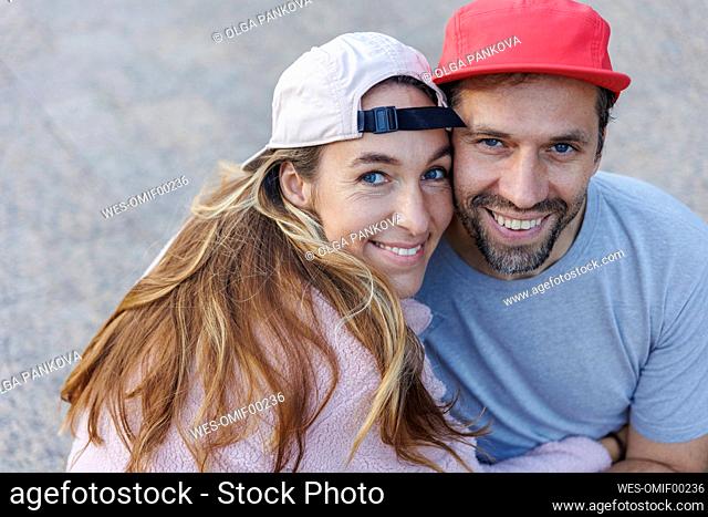 Happy couple wearing caps embracing each other