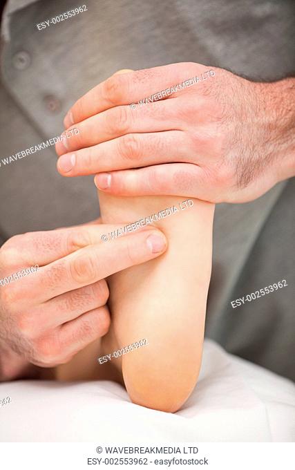 Two fingers pressing the sole of a foot in a room