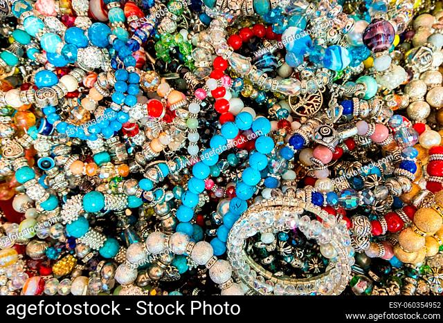 Wallpaper background of stylish bracelets made with colorful stones. Fake jewelery