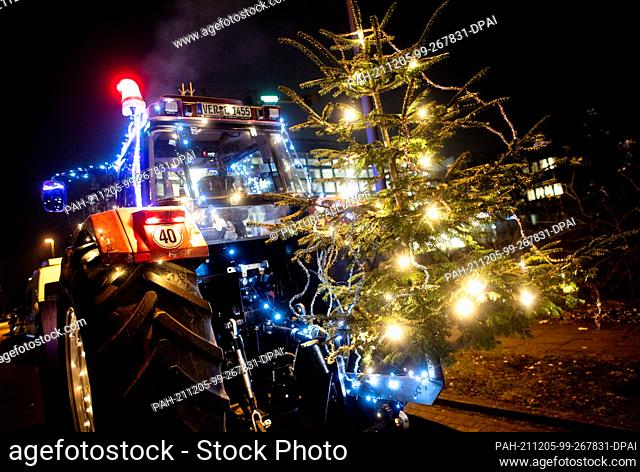 05 December 2021, Bremen: A tractor decorated for Christmas stands before the start of a light drive in the district of Horn-Lehe