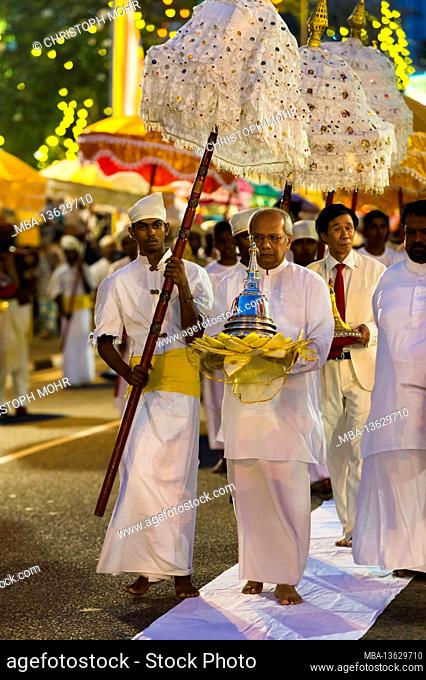 Sri Lanka, Colombo, Gangaramaya temple, the Nawam Maha Perahera festival, men, umbrellas, procession