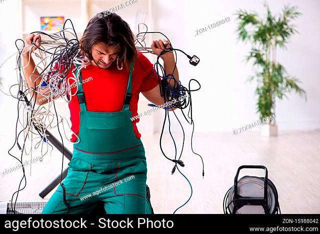 Funny young male electrician working in office