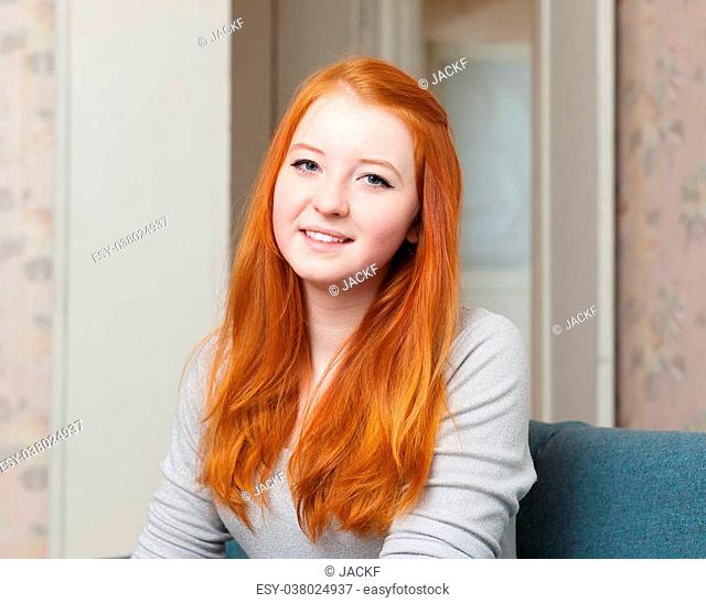 Portrait of red-haired teenager girl at home interior