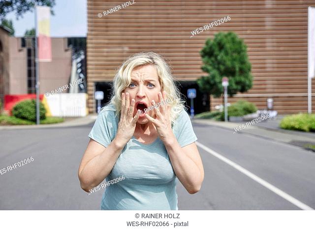 Portrait of shocked woman outdoors
