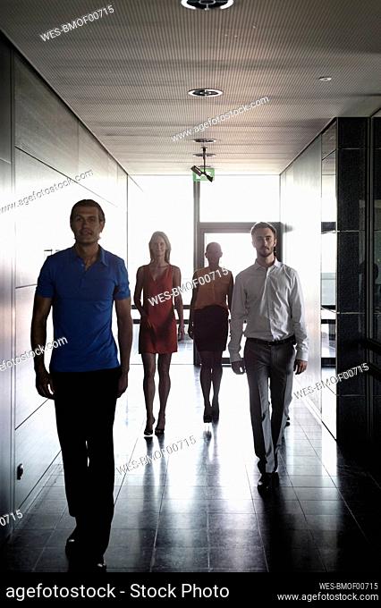 Male and female entrepreneurs walking in corridor at office