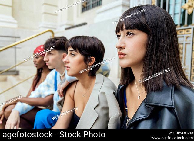 Thoughtful young woman with friends on staircase