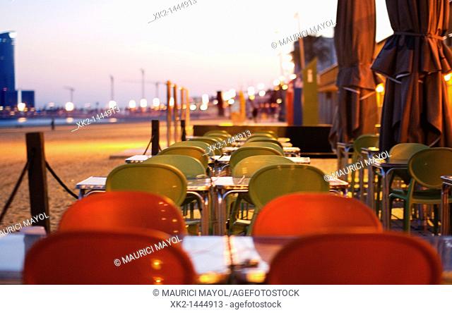 Detalle de mesas en una terraza cerca de la playa de la Barceloneta al anochecer, Barcelona, Spain