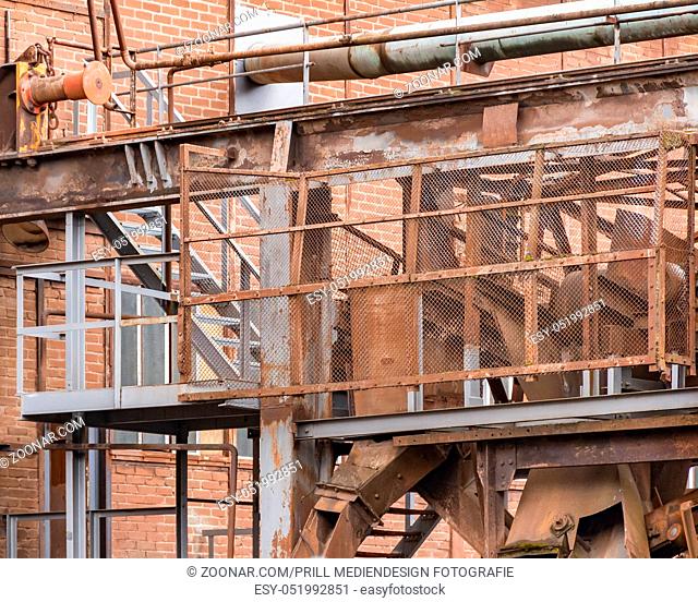 weathered rundown industrial scenery with old corroded steel girders, stairs and metal tubes