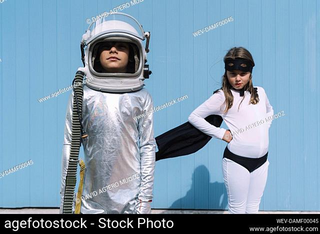 Two kids in astronaut and superhero costumes
