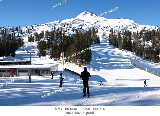 View of Mt Grubigstein, 2233 m, from Grubigalm alpine pasture, station of a ski lift and people skiing, Lermoos, Tyrol, Austria, Europe