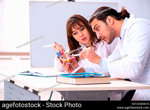 Young male doctor cardiologist and female student in the classroom