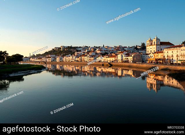 View of Alcacer do Sal cityscape from the other side of the Sado river at sunset