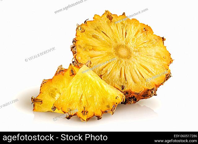 Half pineapple and slices isolated on white background