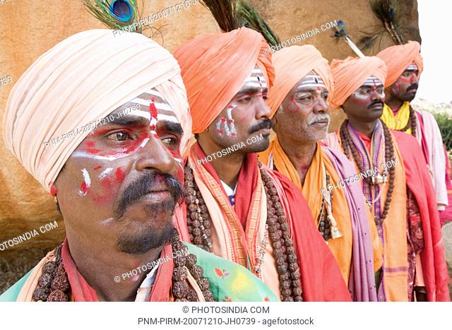 Five sadhus standing in a row, Hampi, Karnataka, India