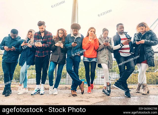 Group of young people staring on their phones avoiding other forms of social contact