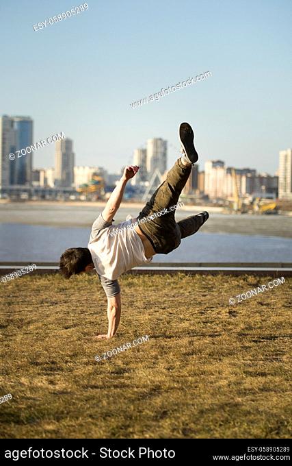 Young man jumping outdoor - sport parkour, telephoto shot