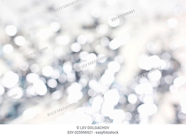 holidays, luxury and background concept - blurred silver christmas lights bokeh