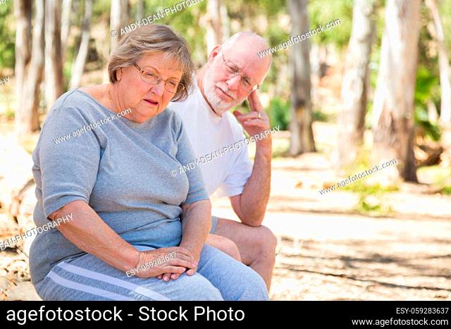 Very Upset Senior Woman Sits With Concerned Husband Outdoors
