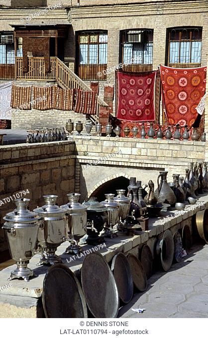 Ancient city. Trading post. Market. Stalls. Goods for sale. Carpets hung on walls. Pots, pewter urns, metal trays