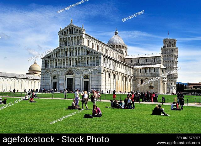 People sitting on the grass in the field of Miracoli in Pisa, Tuscany Region, northern Itali
