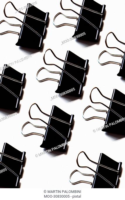 Group of binder clips over white background