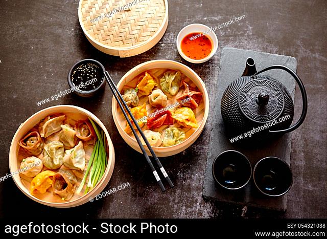 Oriental traditional chinese dumplings served in the wooden steamer placed dark rustic background. Top View composition