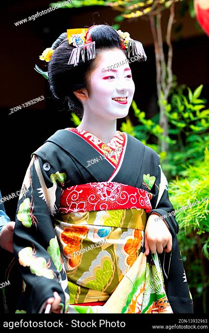 Kyoto, Japan - May 14 2019: Portrait of a young Maiko Geisha who is being led to houses of clientele by her guide in Gion district of Kyoto, Japan