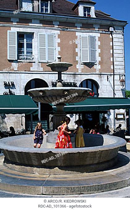 Children playing at fountain Place St. Nikolas Auxerre Burgundy France