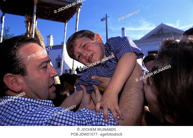 el rocio, a boy is carried over the crowd to touch la paloma blanca