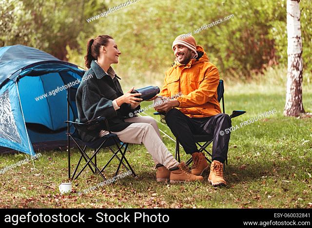 happy couple drinking tea at tent camp