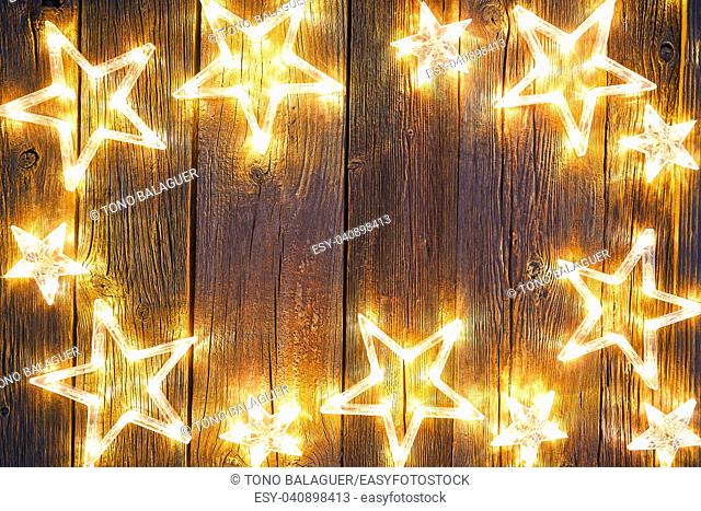 Christmas glowing stars on vintage wooden background copy space
