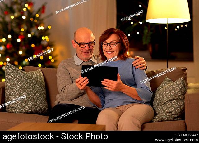 senior couple with tablet pc at home on christmas
