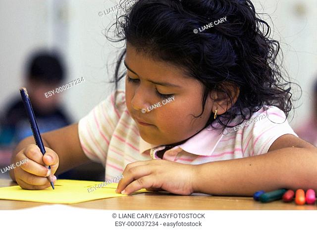 Young Hispanic girl writing
